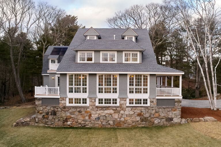 Exterior of a beautiful historic Cape Ann home with many windows and an asphalt roof